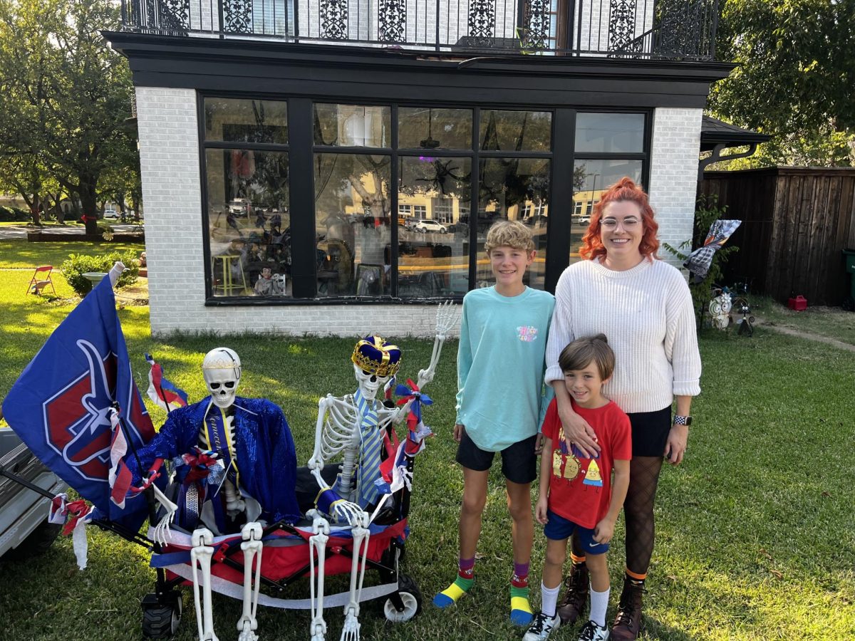 Dana Myrheim and her children pose for a picture next to their homecoming skeleton display.