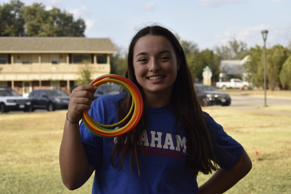 Taylor Lauster, junior, poses with rings from her station. 