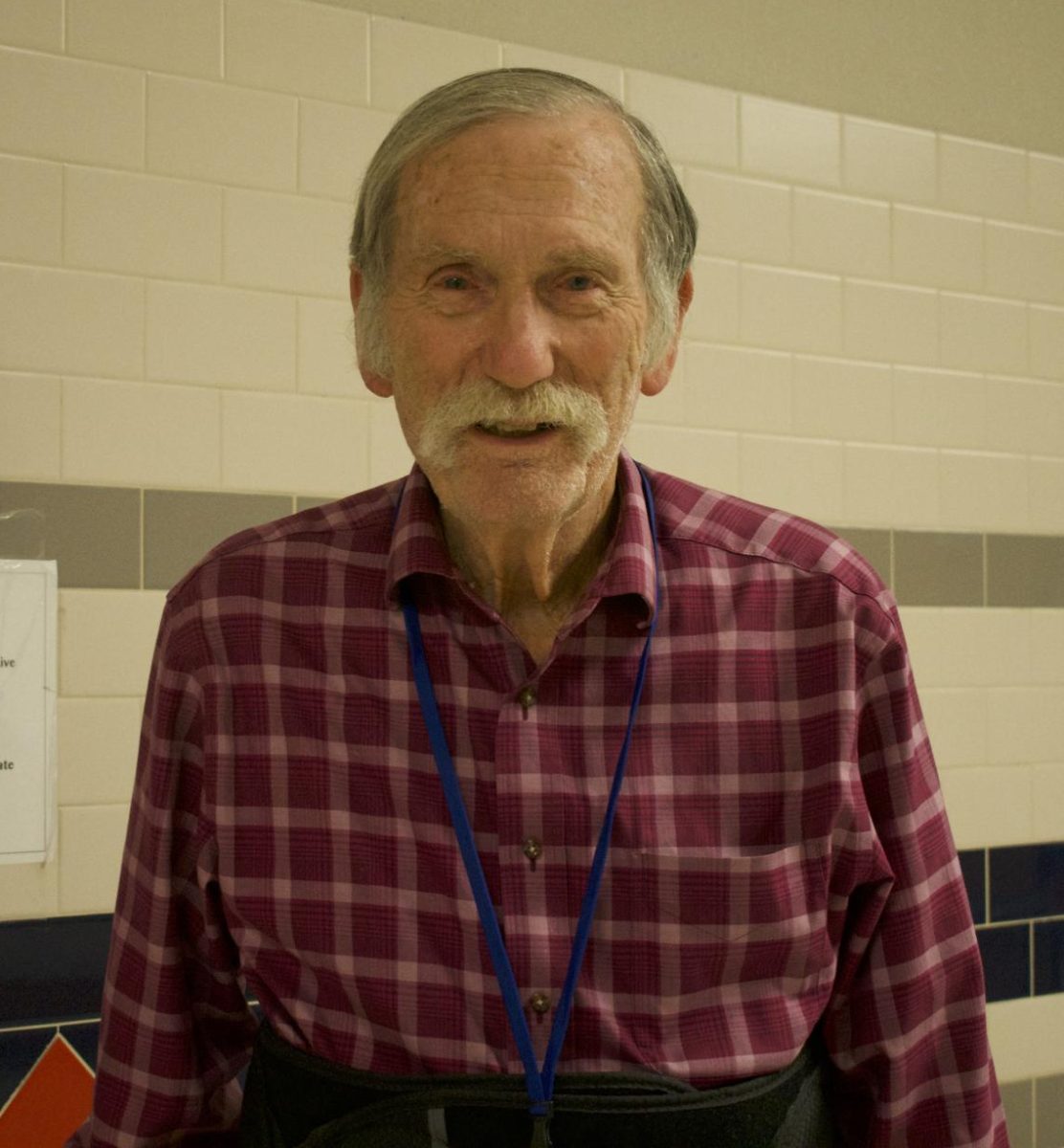Don Sewell smiles for a picture in the hallway